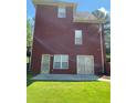 Spacious backyard featuring a patio, lawn, and a view of the home's brick exterior at 3008 Sunrise Ct, Conyers, GA 30094
