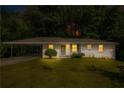 Charming gray home featuring a covered carport and a well-maintained front yard, surrounded by lush greenery at 3055 Henderson Mill Rd, Atlanta, GA 30341