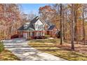 Attractive brick home with an attached garage and long driveway surrounded by colorful trees at 340 Antebellum Way, Fayetteville, GA 30215