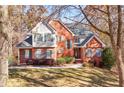 Beautiful two-story brick house with blue shutters, mature trees, and a well-maintained front yard at 340 Antebellum Way, Fayetteville, GA 30215
