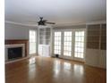 Bright living room with a cozy fireplace, built-in shelving, hardwood floors, and French doors to the outside at 1205 Pebble Bend Dr, Grayson, GA 30017