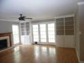 Bright living room with a cozy fireplace, built-in shelving, hardwood floors, and French doors to the outside at 1205 Pebble Bend Dr, Grayson, GA 30017