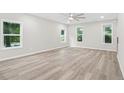 Bright living room featuring sleek wood flooring and ample natural light from large windows at 156 Club Cir, Stockbridge, GA 30281