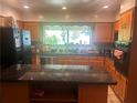 Bright kitchen features wooden cabinets, black appliances, granite countertops, and a large center island at 1164 Rogeretta Ne Dr, Atlanta, GA 30329