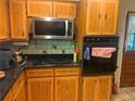 Galley kitchen with wooden cabinets, stainless steel microwave, gas range, and wall oven at 1164 Rogeretta Ne Dr, Atlanta, GA 30329