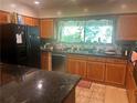 Bright kitchen features wooden cabinets, black appliances, granite countertops and a large center island at 1164 Rogeretta Ne Dr, Atlanta, GA 30329