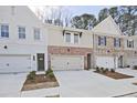 Three well-kept townhouses, showcasing a mix of painted brick and neutral siding, and a one-car garage at 693 Sunstone Ln, Lawrenceville, GA 30043