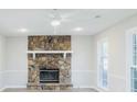 Bright living room featuring a stone fireplace, neutral walls and trim, and modern ceiling fan at 1391 Warrenton Hunt, Lawrenceville, GA 30043