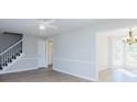 Open-concept living room with staircase, new floors, and elegant chandelier in the adjacent dining area at 1391 Warrenton Hunt, Lawrenceville, GA 30043