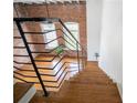 Unique wood staircase with modern railing leading to the loft and showcasing brick wall and large windows at 1596 Cleveland Ave # 301, East Point, GA 30344
