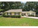 Inviting yellow home boasting manicured landscaping and an expansive green lawn at 2466 Country Club Dr, Conyers, GA 30013