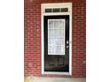 A black front door with glass panels is set into the brick facade with white trim at 3884 Grovemont Pl, Duluth, GA 30096