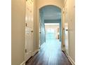 Hallway with arched doorway, leading to an open concept living space and vinyl plank flooring at 3884 Grovemont Pl, Duluth, GA 30096