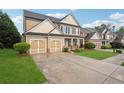 Charming two-story home with a two-car garage and driveway, showcasing its inviting curb appeal at 2040 Village Green Dr, Fairburn, GA 30213