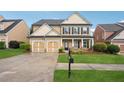 Charming two-story home with a two-car garage, covered porch and a well-maintained lawn at 2040 Village Green Dr, Fairburn, GA 30213