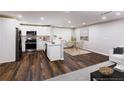 Kitchen and dining area with stainless steel appliances, wood floors, and bright lighting at 6494 Bimini Dr, Forest Park, GA 30297