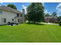 Large, well-maintained backyard with mature trees, a patio set, and a view of neighboring houses at 1055 Havenstone Walk, Lawrenceville, GA 30045
