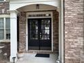 Elegant double front doors with glass panels, framed by white columns and brick facade at 1055 Havenstone Walk, Lawrenceville, GA 30045
