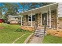Inviting front porch with decorative railings and brick accents, perfect for relaxing outdoors at 135 Buckhurst Way, Atlanta, GA 30349