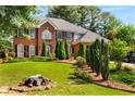 Charming two-story brick home with well-manicured front yard and lush landscaping at 1490 Rivershyre Pkwy, Lawrenceville, GA 30043