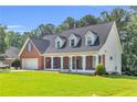 Beautiful exterior showcasing a brick facade, lush lawn, and a welcoming porch with decorative columns at 1945 Kevin Se Dr, Conyers, GA 30013