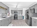 Modern kitchen featuring gray cabinets, stainless steel appliances, and light wood-look flooring at 1945 Kevin Se Dr, Conyers, GA 30013