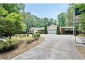 Inviting single-story home with a well-manicured lawn, a curved driveway, and a two-car garage with car port at 280 W Knight W Rd, Mcdonough, GA 30252