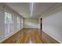 Spacious living room with hardwood floors, white trim, and ample natural light from three large windows at 5739 Cobb Mdw, Norcross, GA 30093