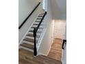 Elegant staircase featuring wood treads, white risers, and a black handrail at 602 Birch River Ln, Lawrenceville, GA 30043