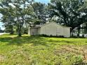 Exterior shot of a modest home surrounded by mature trees and an expansive grassy lawn at 1891 Bennett Rd, Grayson, GA 30017