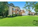 Lovely two-story brick home with a green lawn and mature trees at 7505 Brookwood Way, Cumming, GA 30041