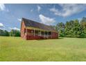 Rear view of brick house with a covered patio and spacious backyard at 172 Lakeview Dr, Newborn, GA 30056