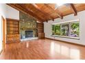 Bright living room with hardwood floors, stone fireplace with wood mantel, built-in bookcases, and large picture window at 3442 Winter Wood Trl, Marietta, GA 30062