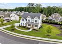 Aerial view of a two-story white home with a landscaped yard nestled in a serene, wooded neighborhood at 6080 Simone St, Acworth, GA 30101