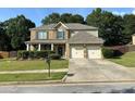 Inviting two-story home with a two car garage and well-maintained front lawn with landscaped garden at 2380 Cain Cir, Dacula, GA 30019