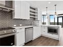 Contemporary kitchen with stainless steel appliances, and open shelving plus island and pendant lights at 788 W Marietta Nw St # 1404, Atlanta, GA 30318