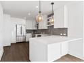 Airy kitchen features a large white island, stainless steel appliances, and modern pendant lighting at 788 W Marietta Nw St # 1404, Atlanta, GA 30318