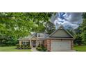 A charming single Gathering house featuring a brick facade, two car garage, and manicured lawn at 9187 Plantation Cir, Covington, GA 30014