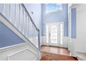 Inviting entryway featuring high ceilings, beautiful blue walls, and a staircase with white railing at 273 Baywood Xing, Hiram, GA 30141