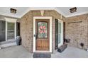 Attractive front door with decorative window, wreath, and brick facade enhancing curb appeal at 212 Thorncliff Way Way, Acworth, GA 30101