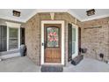 Elegant front door with brick surround and decorative wreath, flanked by planters at 212 Thorncliff Way Way, Acworth, GA 30101