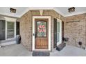 Inviting front entrance featuring a wooden door with decorative glass and brick facade at 212 Thorncliff Way Way, Acworth, GA 30101
