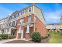 View of the side of the townhome with brick and siding; also features a well-maintained lawn at 801 Tulip Poplar Way # 2501, Lawrenceville, GA 30044