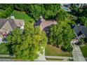 An aerial view of a home surrounded by mature trees in a neighborhood with a community pool at 805 River Valley Dr, Dacula, GA 30019