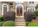 Elegant double front doors with stone steps and manicured bushes create an inviting entrance at 106 April Walk, Mcdonough, GA 30253