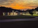 Expansive white home at dusk with a well manicured lawn and a beautiful sky overhead at 1169 Hodges Cir, Mansfield, GA 30055