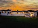 Expansive white home at sunset with a long raised patio and lawn down to the hillside at 1169 Hodges Cir, Mansfield, GA 30055