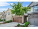 Beautiful townhouse with a two-car garage, manicured landscaping, and a tree adding natural beauty at 3246 Spicy Cedar Ln, Lithonia, GA 30038