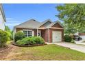 Single-story brick home featuring a well-manicured front yard with a one-car attached garage at 401 Buckboard Ln, Locust Grove, GA 30248