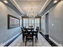 Elegant dining room featuring a decorative chandelier, wood-paneled ceiling, and dark hardwood floors and neutral wall color at 5965 Vista Brook Dr, Suwanee, GA 30024